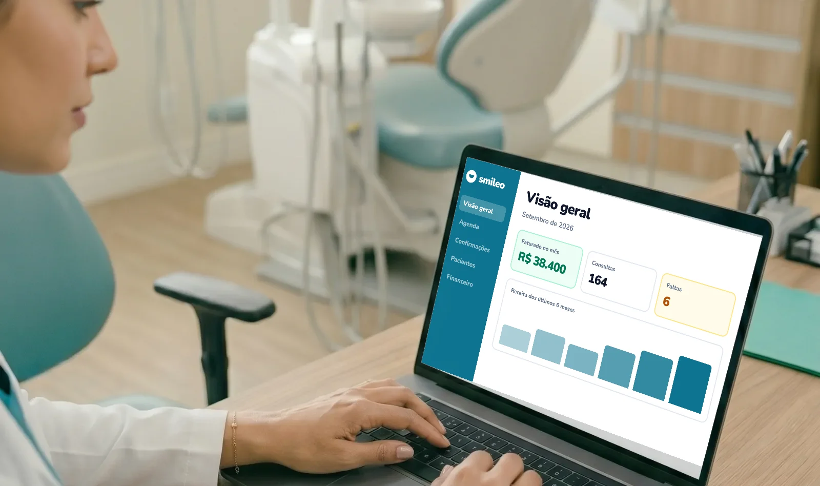 Dentista acompanha no notebook os indicadores do mês da clínica: faturamento, consultas e faltas